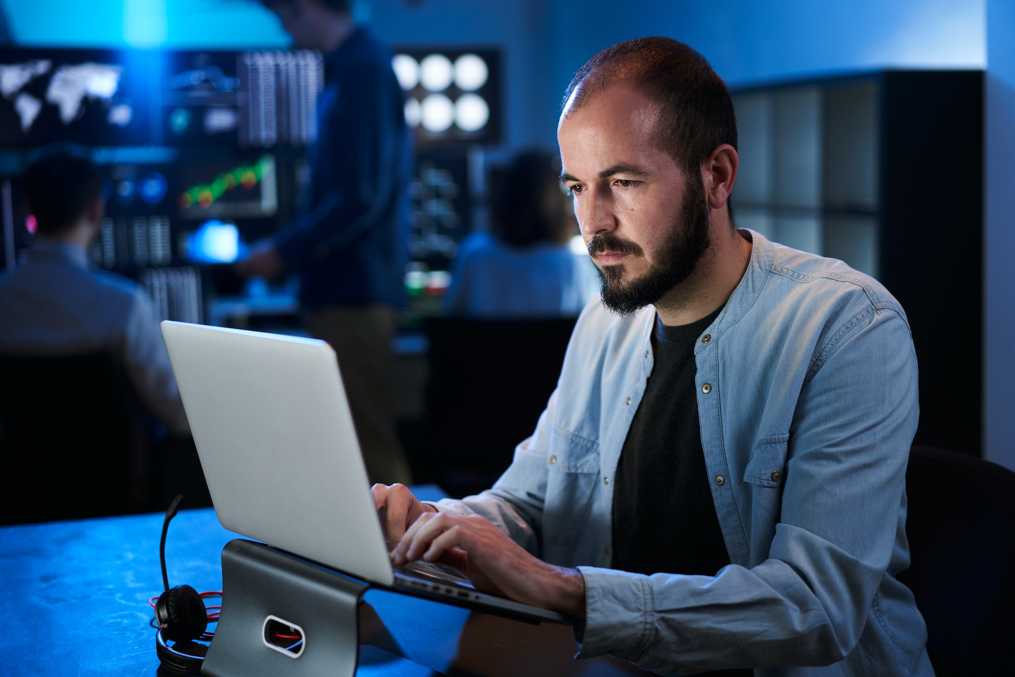 Financial Analyst Working on a Computer with Multi-Monitor Workstation