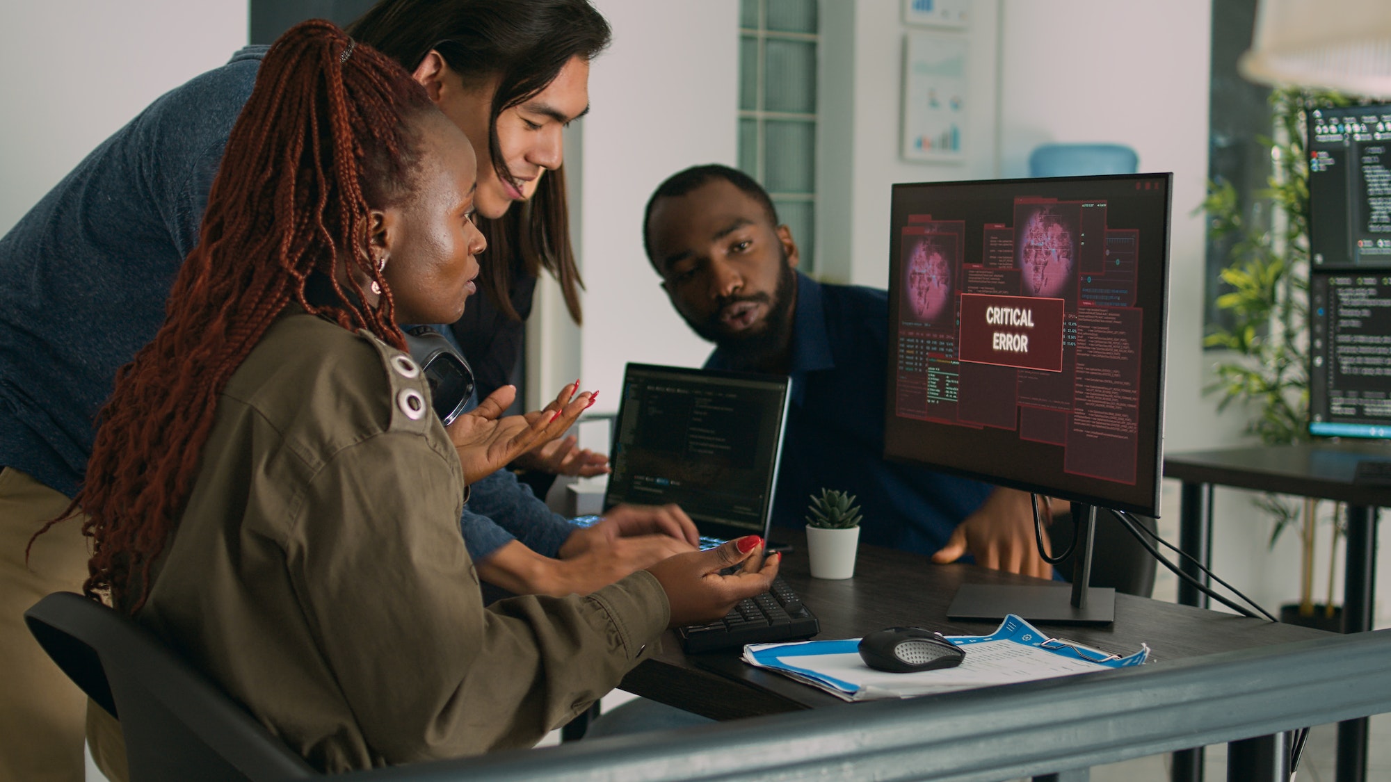 Multiethnic group of it engineers dealing with hacking alert