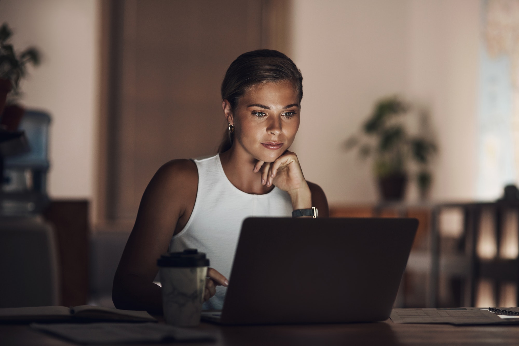 Shot of a young businesswoman using a laptop during a late night at work