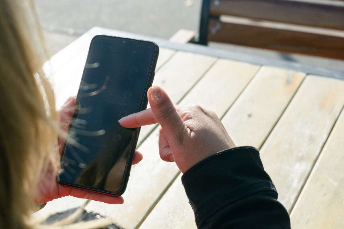 Finger interacting with mobile touch screen interface with tap targets